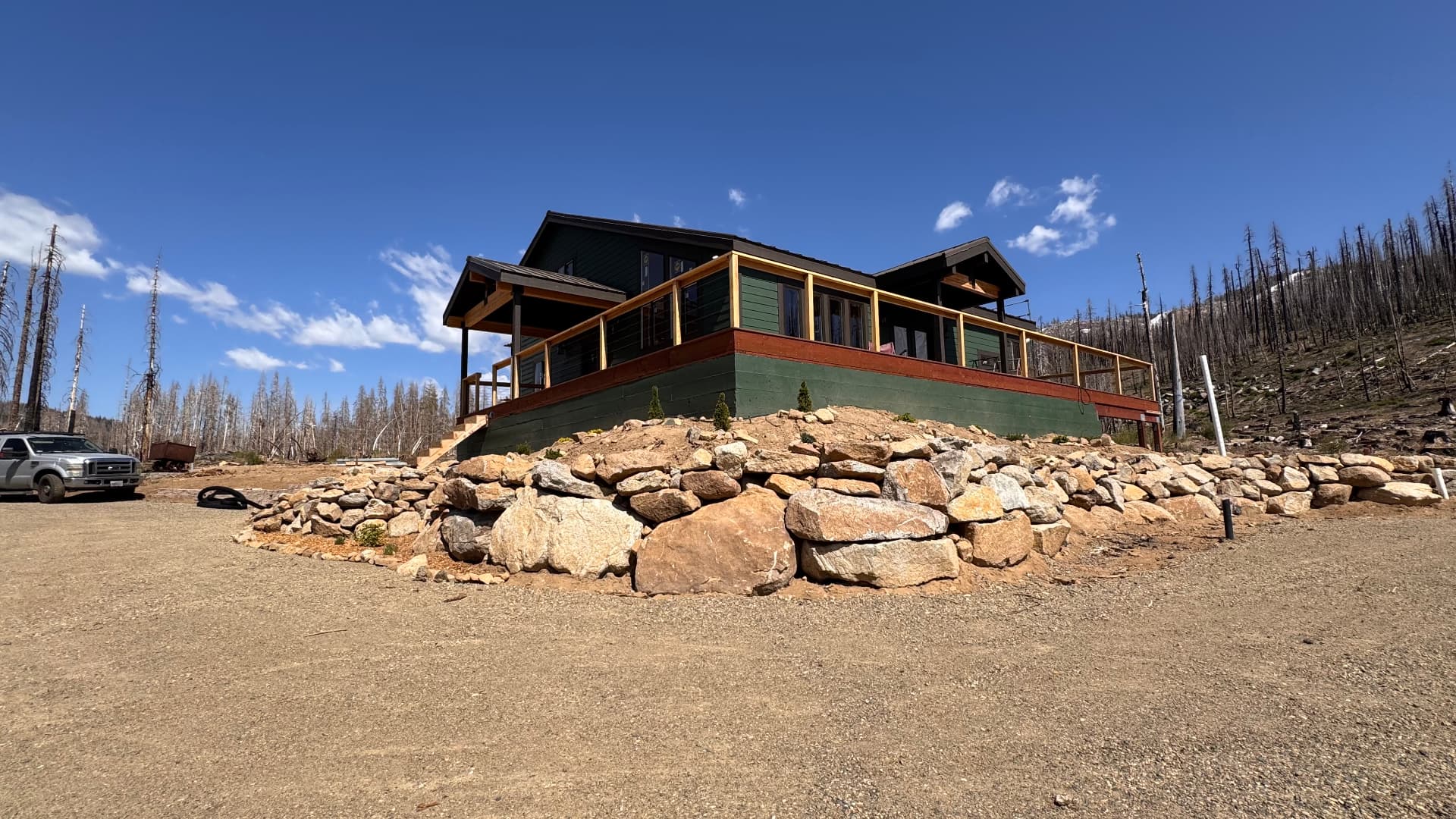 Rock retaining wall and pad built around a mountain cabin
