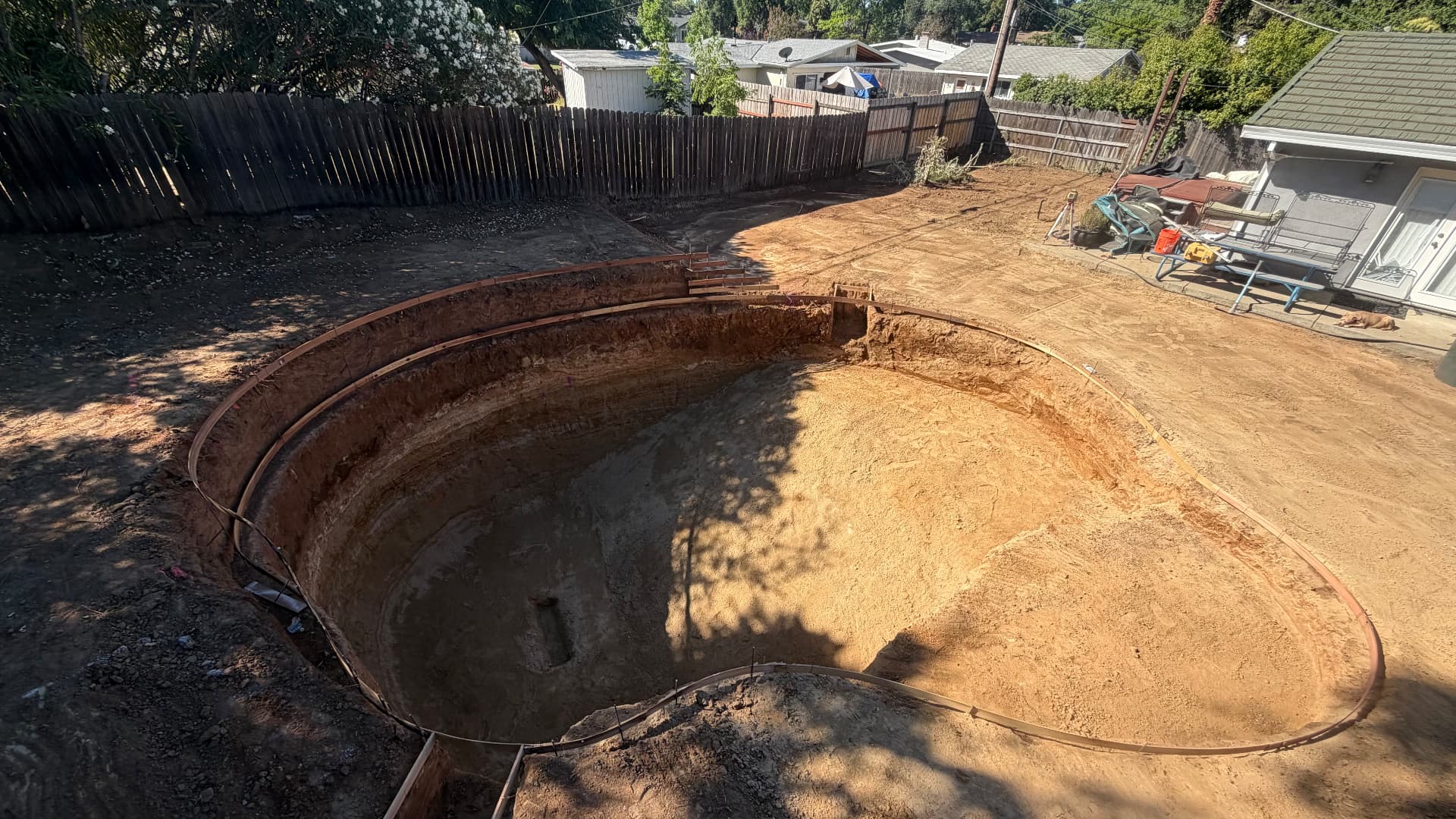 Backyard swimming pool excavation shaped and formed in a residential yard