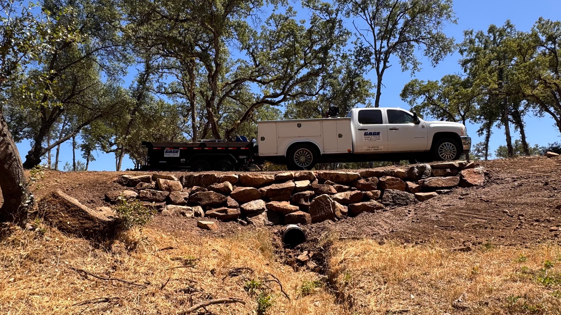 Culvert install with rock headwall and Gage service truck on site